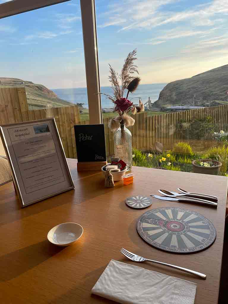 FOOD 17 A dining table set for breakfast with view over the garden and out to sea