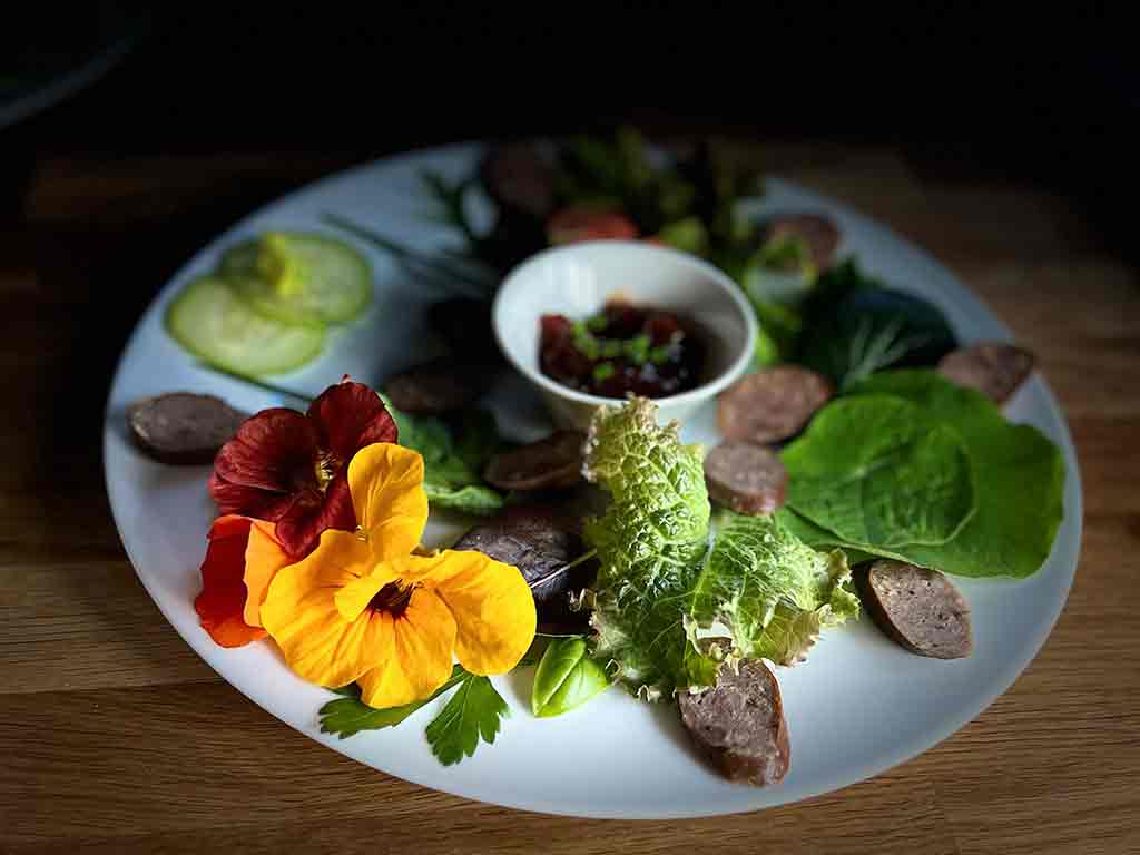 FOOD 21 Slices of smoked venison sausage with salad leaves, edible flowers & chutney